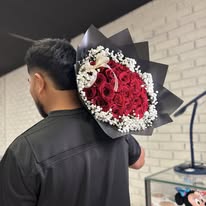 Hand-tied red rose bouquet wrapped in black paper by Three M Bloom