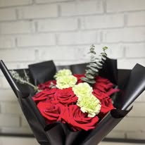 Red rose and carnation bouquet wrapped in black paper