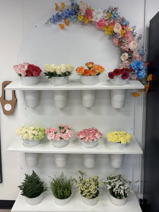 Three M Bloom flower wall display with fresh bouquets